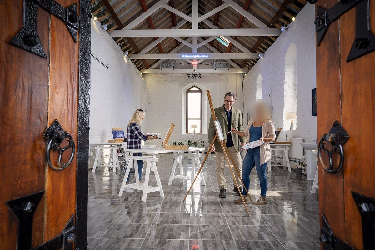Inside The Burren Art Gallery — a bright converted church space with people painting at easels